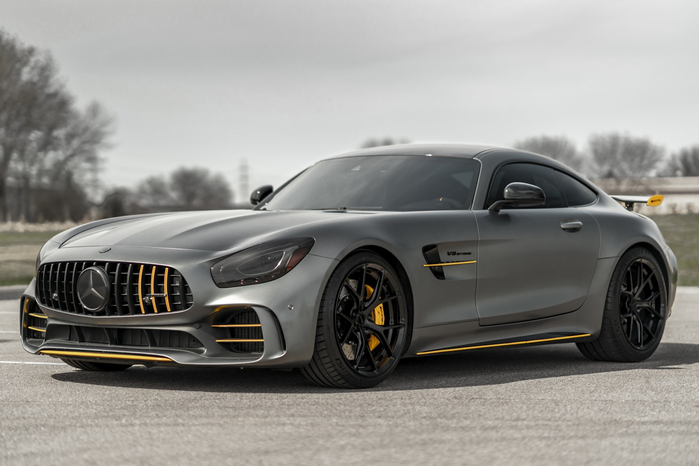 Mercedes-AMG GT R gris grafito con acentos amarillos fotografiado de tres cuartos.