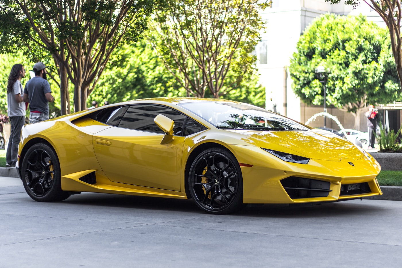 Lamborghini Huracán amarillo estacionado en una calle arbolada.